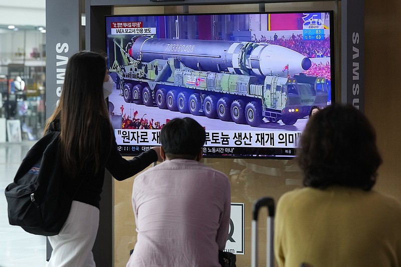 People watch a TV screen showing a file image of a North Korean missile in a military parade during a news program at the Seoul Railway Station in Seoul, South Korea, Monday, Aug. 30, 2021. North Korea appears to have restarted the operation of its main nuclear reactor used to produce weapons fuels, the U.N. atomic agency said, as the North openly threatens to enlarge its nuclear arsenal amid long-dormant nuclear diplomacy with the United States. Korean letters read: "The reactor produces plutonium." (AP Photo/Ahn Young-joon)