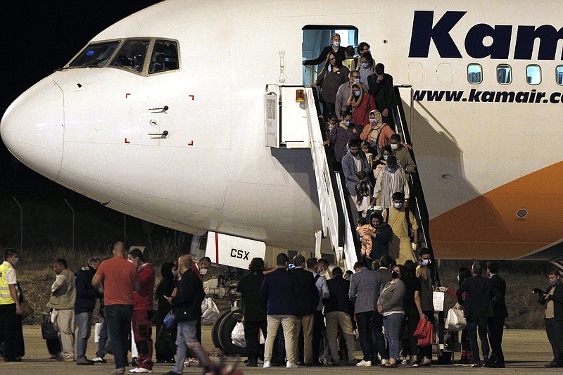 Afghan evacuees disembark a plane after landing at Skopje International Airport, North Macedonia, late Monday, Aug. 30, 2021. North Macedonia hosted the first group of about 150 Afghan evacuees who made it out of their country after days of chaos near the Kabul airport, following the takeover by the Taliban. (AP Photo/Boris Grdanoski)