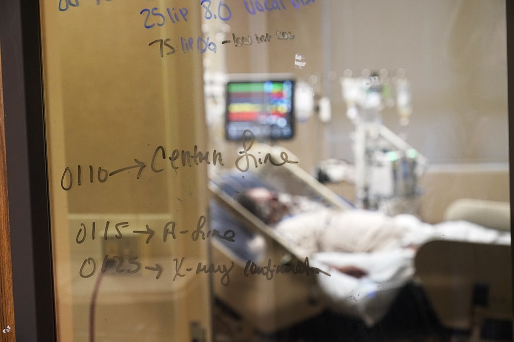 FILE - In this Wednesday, Aug. 18, 2021 file photo, Medical notations are written on a window of a COVID-19 patient's room in an intensive care unit at the Willis-Knighton Medical Center in Shreveport, La.  Louisiana hospitals already packed with patients from the latest coronavirus surge are now bracing for a powerful Category 4 hurricane, which is expected to crash ashore Sunday, Aug. 28, 2021. (AP Photo/Gerald Herbert, File)