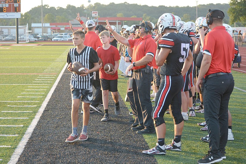 Al Gaspeny/Special to the McDonald County Press
Coaches signal in plays from the sidelines during McDonald County's 33-22 victory over Aurora on Friday night.