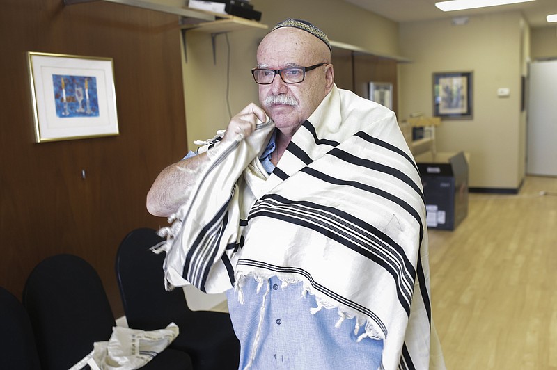 Rabbi Cantor Sam Radwine drapes himself in a robe as he poses for a portrait at Congregation Etz Chaim. Radwine was recently elevated to rabbi for the Bentonville synogogue.
(NWA Democrat-Gazette/Charlie Kaijo)