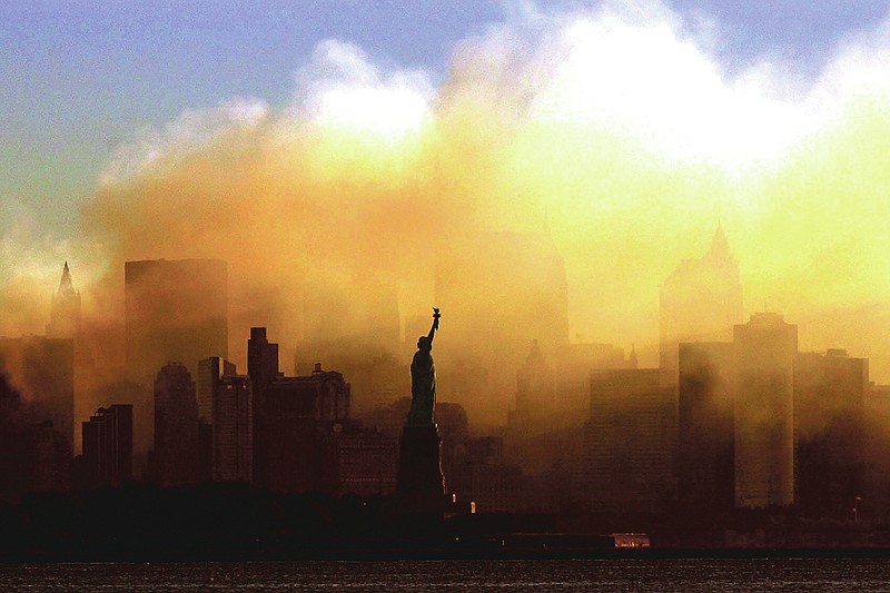 ADVANCE FOR PUBLICATION ON FRIDAY, SEPT. 10, AND THEREAFTER - FILE - In this Saturday, Sept. 15, 2001 file photo, the Statue of Liberty stands in front of a smoldering lower Manhattan at dawn, seen from Jersey City, N.J. The Sept. 11, 2001 terrorist attacks on the United States nearly 20 years ago precipitated profound changes in America and the world. (AP Photo/Dan Loh, File)