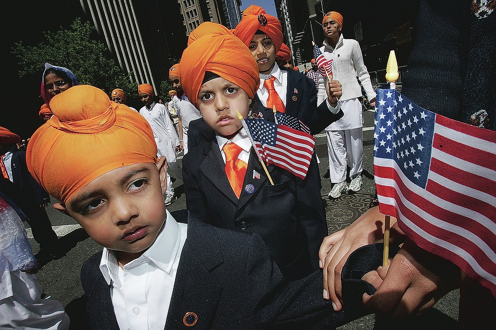 ADVANCE FOR PUBLICATION ON FRIDAY, SEPT. 10, AND THEREAFTER - FILE - In this Saturday, April 29, 2006 photo, children holding U.S. flags march down Broadway during the 19th Annual Sikh Day Parade in New York. Since Sept. 11, 2001, many Sikhs have been mistaken for Muslims and have become targets. As a result, they have been at the forefront of civil rights advocacy against religious and racial profiling. (AP Photo/Hiroko Masuike, File)