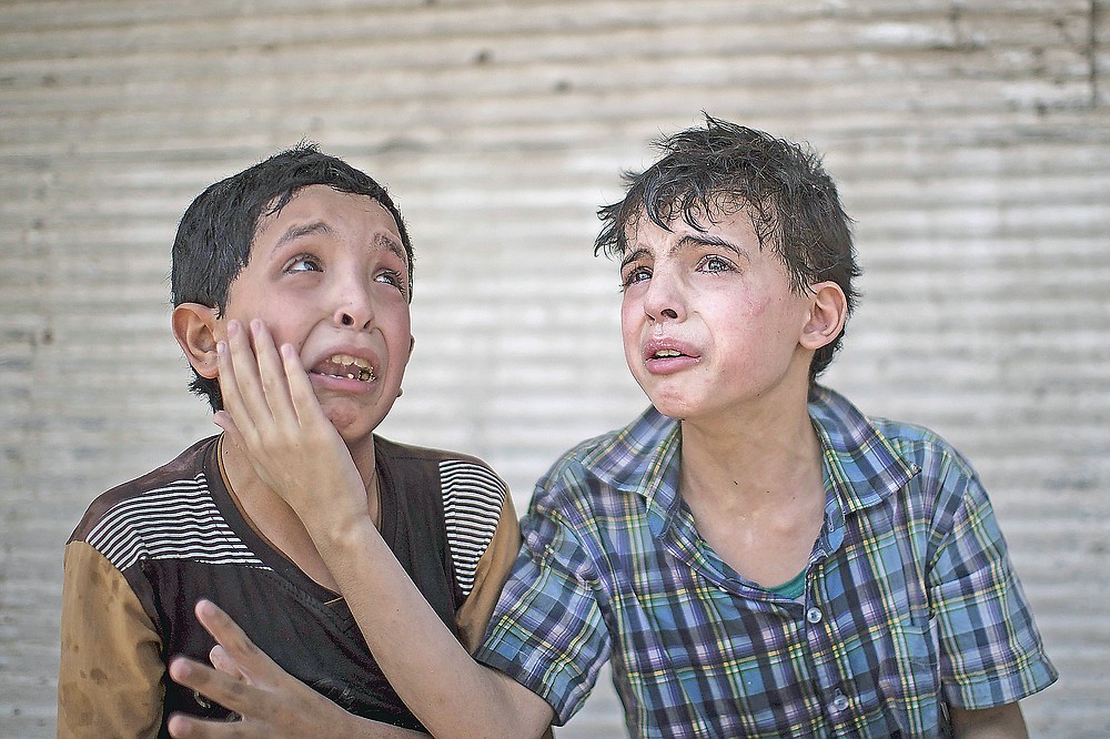 ADVANCE FOR PUBLICATION ON FRIDAY, SEPT. 10, AND THEREAFTER - FILE - In this Saturday, June 24, 2017 file photo, Zeid Ali, 12, left, and Hodayfa Ali, 11, comfort each other after their house was hit and collapsed during fighting between Iraqi forces and Islamic State militants in Mosul, Iraq. The Ali cousins said some of their family members are still under the rubble. (AP Photo/Felipe Dana, File)