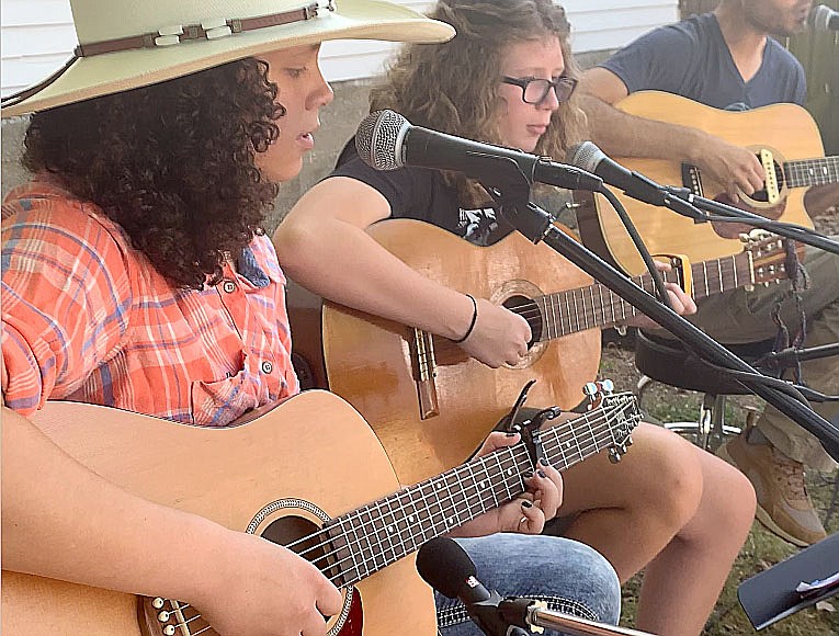 LYNN KUTTER ENTERPRISE-LEADER
Patience Remington of Lincoln has learned to play guitar through Roots Music, a free program sponsored by Historic Cane Hill through Inside Out Studio in Farmington. Here, Patience is singing at Prairie Grove Farmers Market.
