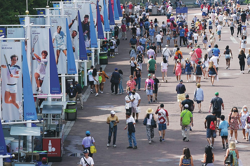Tennis fans walk the grounds of the Billie Jean King National Tennis Center during the first round of the US Open tennis championships, Monday, Aug. 30, 2021, in New York. (AP Photo/Seth Wenig)