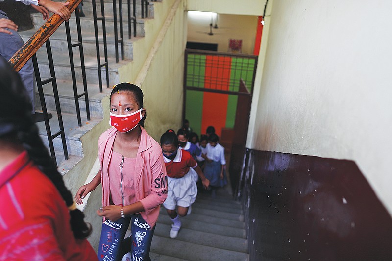 Students walk towards their classrooms on the first day of partial reopening of schools in Prayagraj, India, Wednesday, Sept. 1, 2021. More students in India will be able to step inside a classroom for the first time in nearly 18 months Wednesday, as authorities have given the green light to partially reopen more schools despite apprehension from some parents and signs that infections are picking up again. Schools and colleges in at least six more states will reopen in a gradual manner with health measures in place throughout September. (AP Photo/Rajesh Kumar Singh)