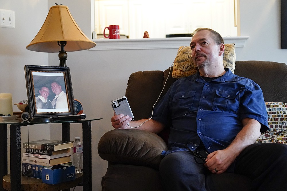 Ed Bisch, who lost his 18-year-old son Eddie to an overdose nearly 20 years ago, listens on speaker phone from his home in Westampton, N.J., to a bankruptcy judge Wednesday, Sept. 1, 2021, on a plan for OxyContin maker Purdue Pharma to settle thousands of lawsuits brought by state and local governments and others over opioids. Bisch, who has spent more than a decade pushing for the Sacklers to be criminally prosecuted, is leading a group of families that are asking the U.S. Justice Department to appeal the settlement. (AP Photo/Matt Rourke)