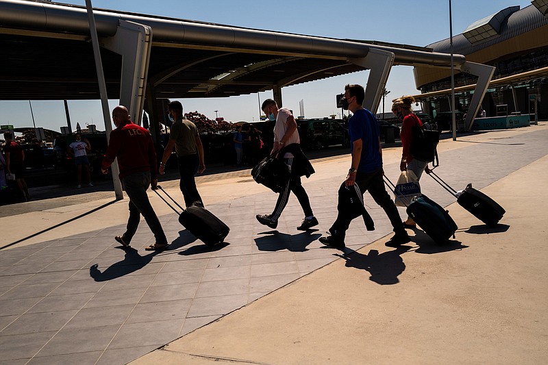 Tourists wheel luggage from the arrivals terminal at Faro Airport in Faro, Portugal, on May 29, 2021. MUST CREDIT: Bloomberg photo by Jose Sarmento Matos.