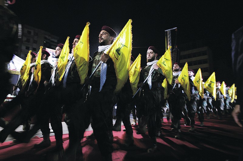 FILE - In this May 31, 2019 file photo, Hezbollah fighters march at a rally to mark Jerusalem day, in the southern Beirut suburb of Dahiyeh, Lebanon. As Lebanon sinks deeper into poverty and collapse, many Lebanese are more openly criticizing the Iran-backed Hezbollah, blaming it for its role in the devastating, multiple crises plaguing the country. This includes a dramatic currency crash and severe shortages in medicines and fuel that has paralyzed the country. (AP Photo/Hassan Ammar, File)