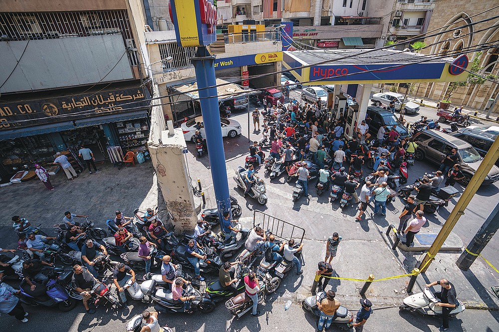Motorcycle drivers wait to get fuel at a gas station in Beirut, Lebanon, Tuesday, Aug. 31, 2021. Lebanon is struggling amid a two-year economic and financial crisis that the World Bank has described as among the worst the world has witnessed since the mid-1850s. The crisis has left Lebanese suffering from severe shortages in fuel and basic goods like baby formula, medicine and spare parts. (AP Photo/ Hassan Ammar)