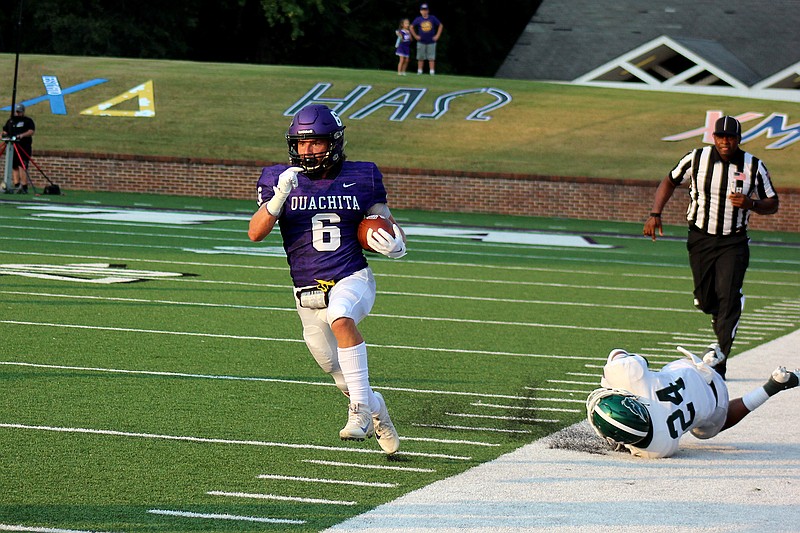 Ouachita Baptist&#x2019;s Connor Flannigan (6) runs down the sideline after Oklahoma Baptist&#x2019;s Trajan Lands (24) misses a tackle during Thursday&#x2019;s game at Cliff Harris Stadium. - Photo by James Leigh of The Sentinel-Record