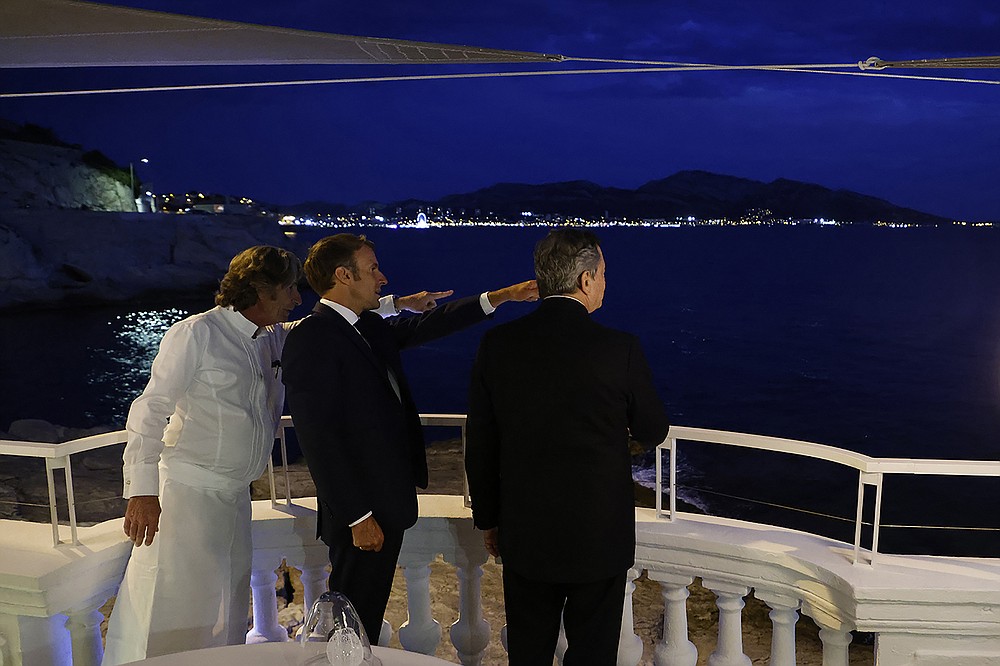 Le président français Emmanuel Macron, au centre, le chef français Gerald Bassedat, à gauche, et le Premier ministre italien Mario Draghi se rencontrent avant le dîner au restaurant