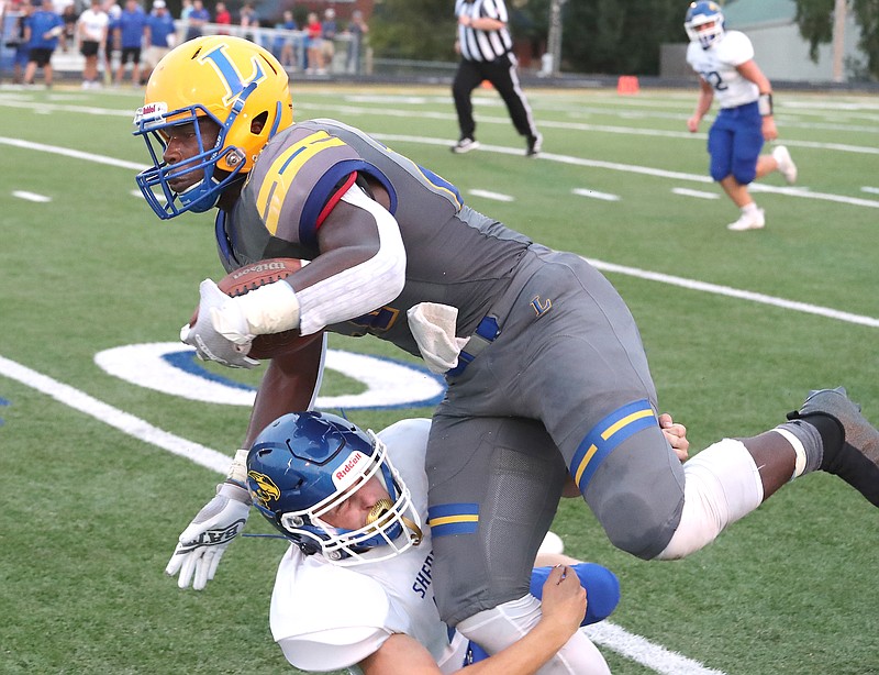 Lakeside’s Braylen Russell (27) is brought down by Sheridan’s Wesley Shumate (19) after a gain Friday at Chick Austin Field. - Photo by Richard Rasmussen of The Sentinel-Record