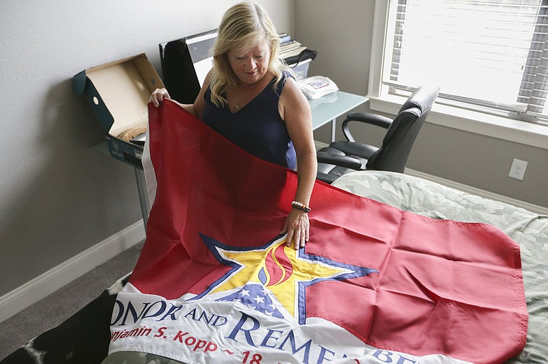 Gold Star mom Jill Stephenson runs her hand across an Honor and Remember flag Monday given to her after her son died. Check out nwaonline.com/210905Daily/ for today’s photo gallery.
(NWA Democrat-Gazette/Charlie Kaijo)