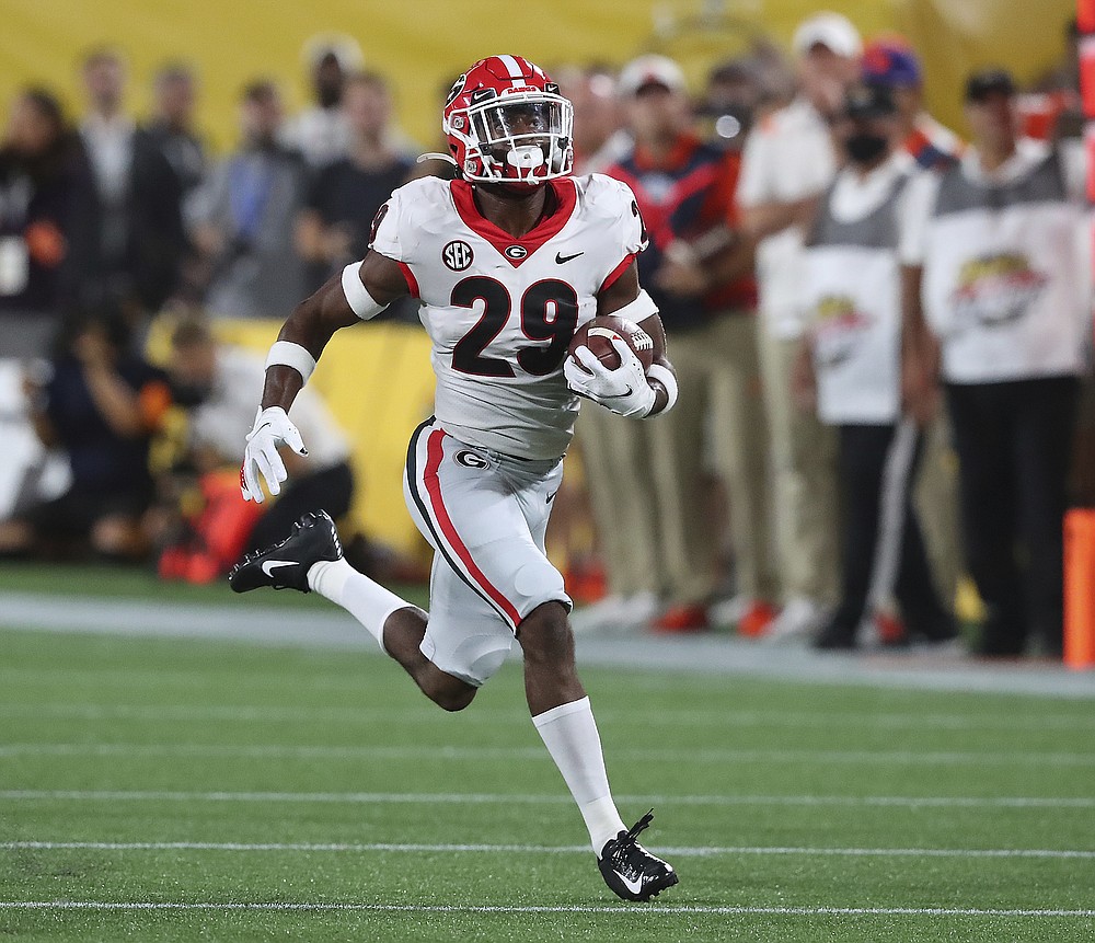 Georgia defensive back Christopher Smith celebrates with Kelee Ringo, left,  after intercepting …