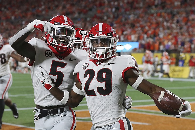 Georgia defensive back Christopher Smith celebrates with Kelee Ringo, left, after intercepting a Clemson pass and returning it for a touchdown during the second quarter of an NCAA college football game Saturday, Sept. 4, 2021, in Charlotte, N.C. (Curtis Compton/Atlanta Journal-Constitution via AP)