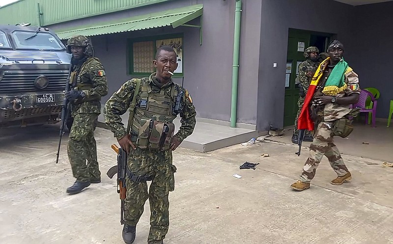 In this image made from video, unidentified soldiers patrol near the office of the president in the capital Conakry, Guinea Sunday, Sept. 5, 2021. Guinea's new military leaders sought to tighten their grip on power after overthrowing President Alpha Conde, warning local officials that refusing to appear at a meeting convened Monday would be considered an act of rebellion against the junta. (AP Photo)