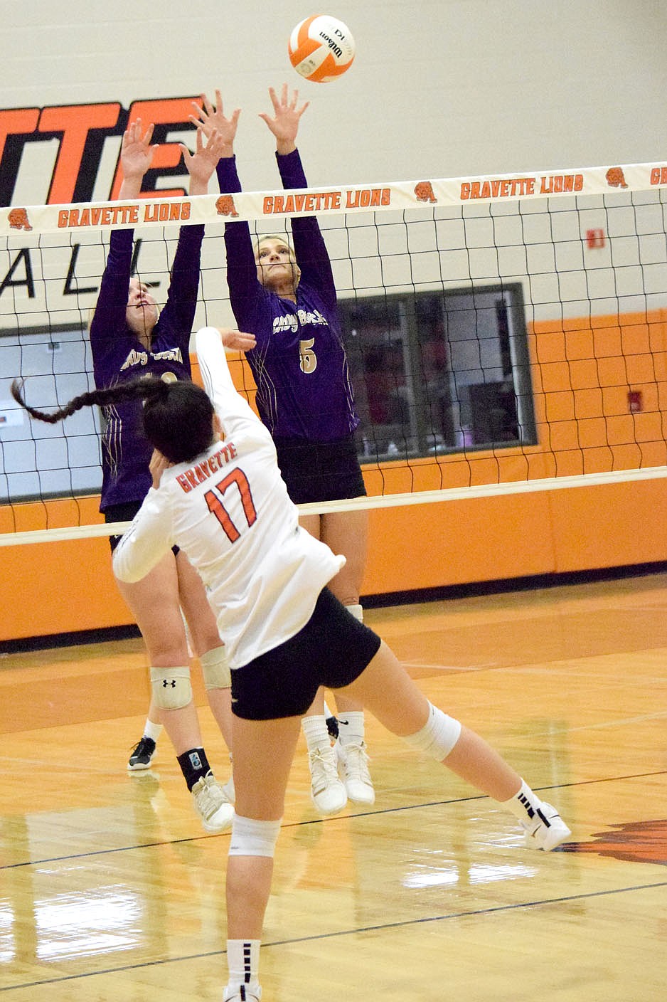 Westside Eagle Observer/MIKE ECKELS
Ella Pinches (17) smashes the ball past a pair of Lady Bobcat defenders for a Lady Lion point during the third set of the Gravette-Berryville varsity volleyball match in Gravette Thursday night. The Lady Lions took the win in three straight sets over the Lady Bobcats.