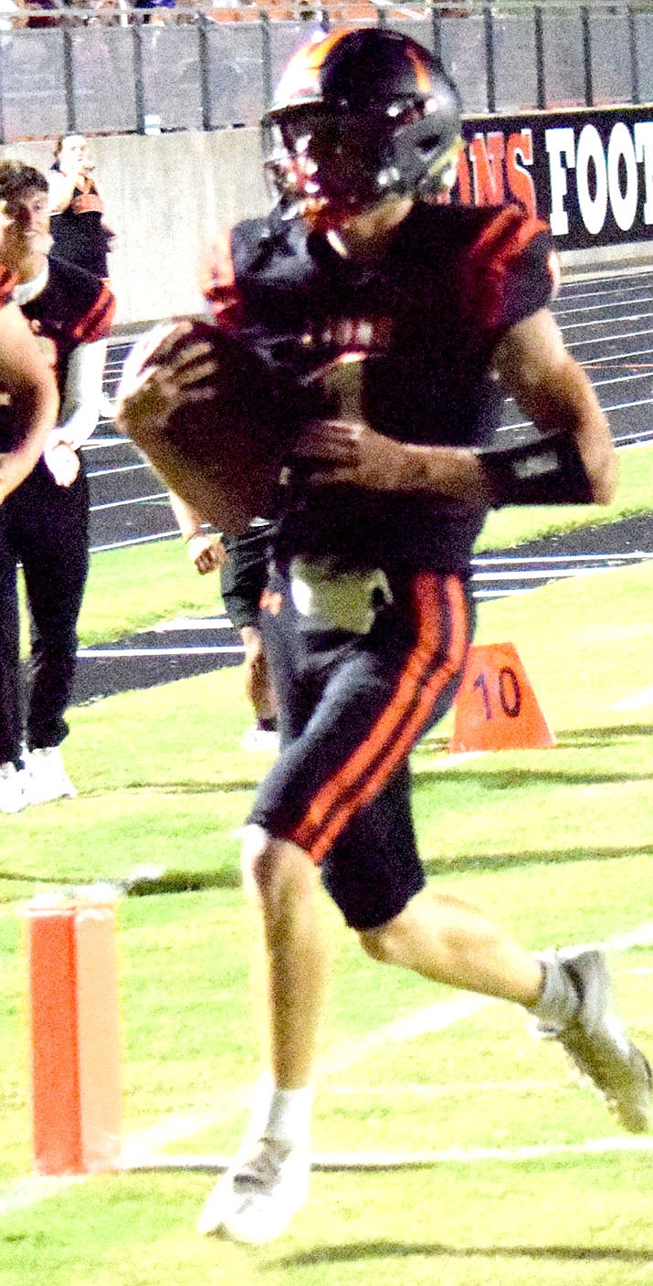 Westside Eagle Observer/MIKE ECKELS
On a quarterback keeper, Rhett Hilger eludes several Tiger tackles at the 15 yard line and finds an opening in the end zone for the Lions' first touchdown of the night. The Pryor, Oklahoma, Tigers made the trip to Lion Stadium in Gravette Friday night for a nonconference showdown with the Lions.