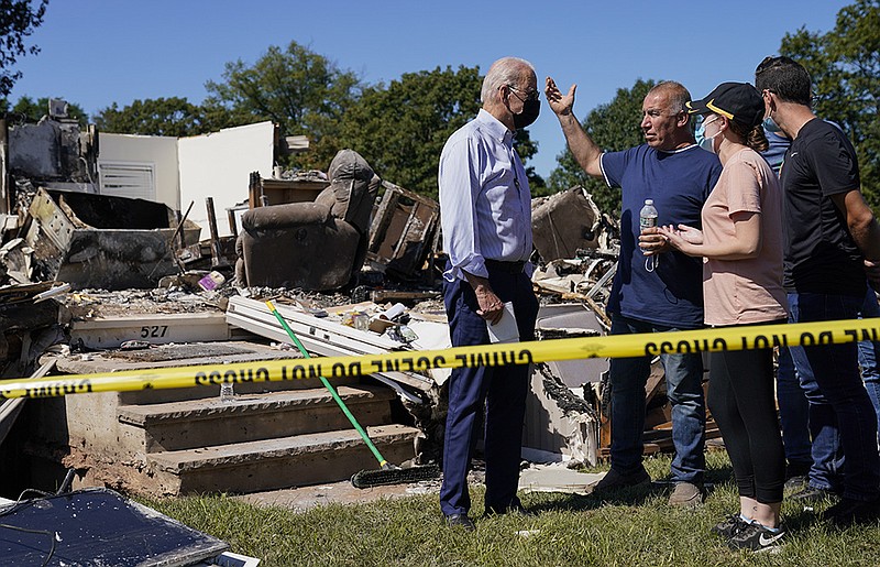 President Joe Biden talks to people as he tours a neighborhood impacted by Hurricane Ida, Tuesday, Sept. 7, 2021, in Manville, N.J. (AP Photo/Evan Vucci)