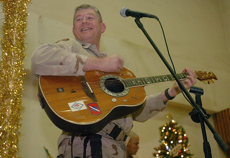 Col. Mike Ross, deputy brigade commander, joins in the music Dec. 23, 2004, during the Christmas Eve festivities with other soldiers at Camp Gunslinger in Baghdad.
(Democrat-Gazette file photo)