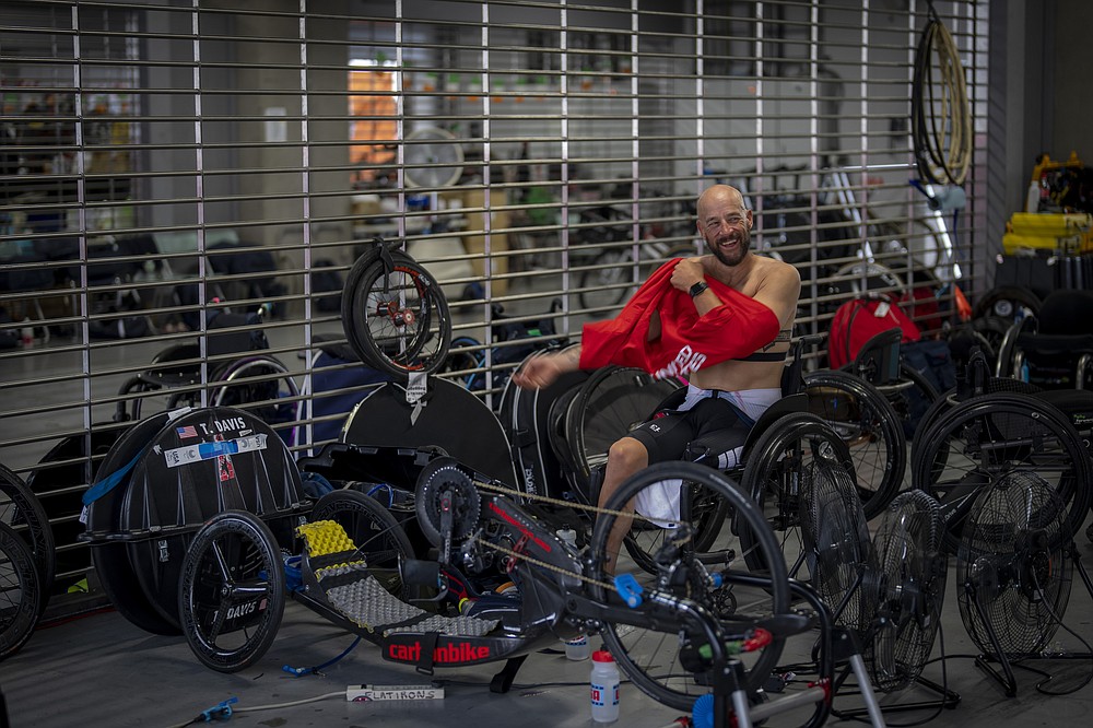 Tom Davis, of the U.S., changes clothes after taking part in the Men's H4 Time Trial at the Fuji International Speedway at the Tokyo 2020 Paralympics, Tuesday, Aug. 31, 2021, in Tokyo, Japan. Davis, 44, has emerged as one of the world&#x2019;s fastest hand-cyclists, going into the Tokyo competitions with three world championship silver medals and more marathon victories than he can easily count. (AP Photo/Emilio Morenatti)