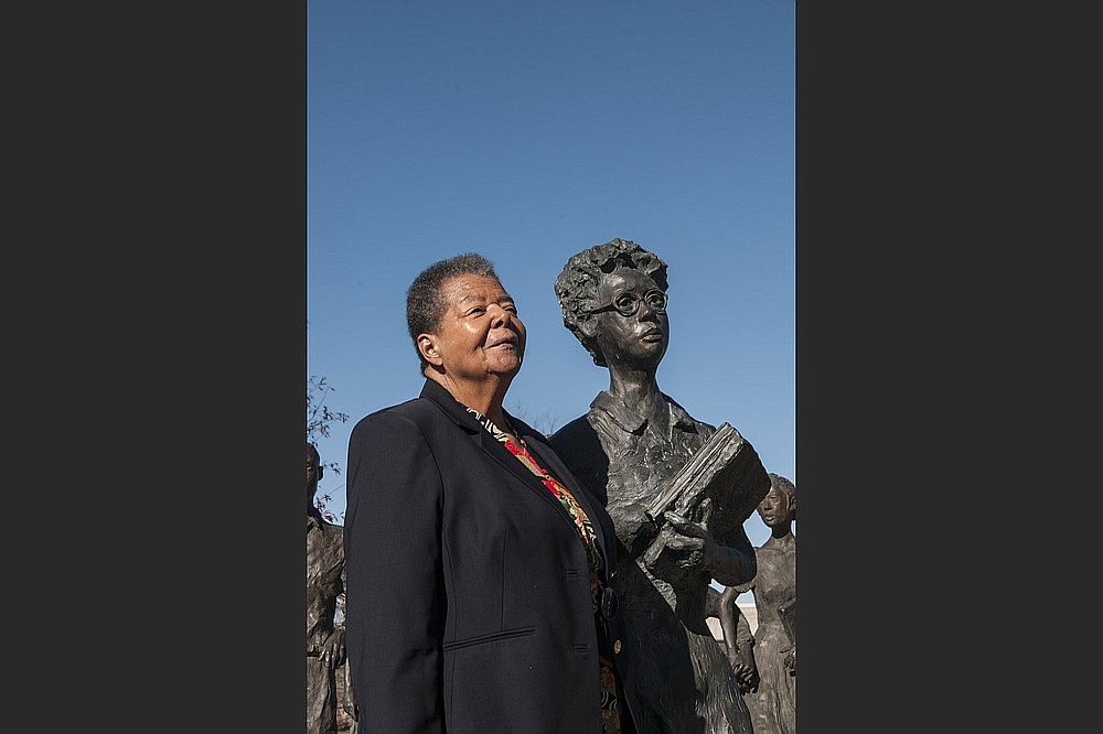 Elizabeth Eckford, in December 2017, stands by a statue of herself as one of the then-teenage Little Rock Nine desegregating Little Rock Central High. (Democrat-Gazette file photo)
