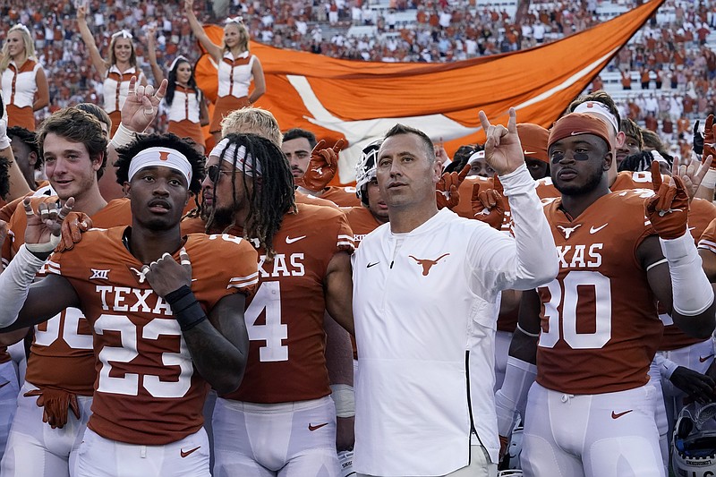 In this Saturday, Sept. 4, 2021, file photo, Texas head coach Steve Sarkisian, center, joins players in singing "The Eyes of Texas" after an NCAA college football against Louisiana-Lafayette, in Austin, Texas. The Texas chapter of the NAACP and a group of UT students have filed a federal civil rights complaint against the University of Texas for its continued use of “The Eyes of Texas” school song, tune with racist elements in its past. The complaint filed Friday, Sept. 3, 2021, with the U.S. Department of Education alleges that Black students and faculty are being subjected to violations of the Civil Rights Act and a hostile campus environment. (AP Photo/Eric Gay)