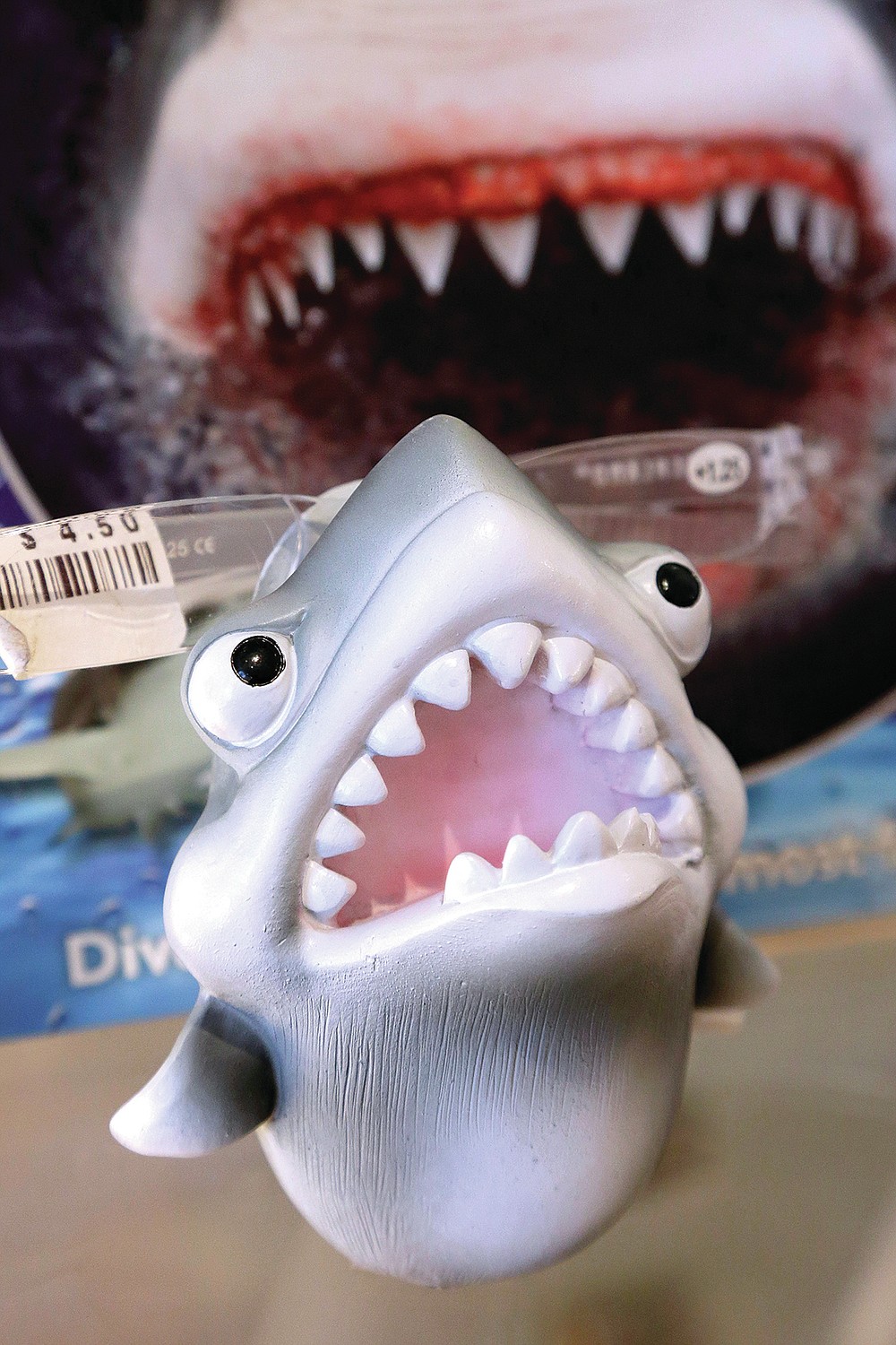 FILE— In this July 2, 2014 file photo, an eye glass holder in the shape of a shark rests on a shelf in a souvenir shop in Chatham, Mass. Cape Cod is slowly embracing its shark reputation, three summers after the popular vacation destination saw its first great white shark attacks in generations. A growing group businesses are cashing in on the shark trend with retail offerings to tourists and charter boat operators giving visitors a chance to see the marine predators up close. (AP Photo/Steven Senne, File)