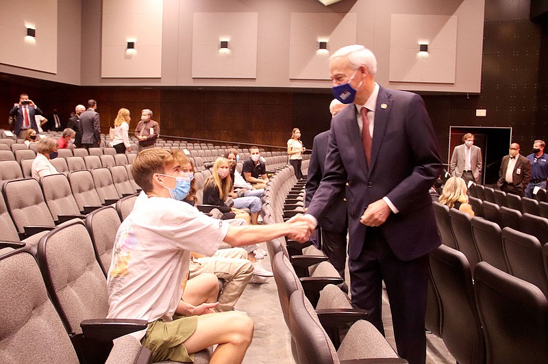 LYNN KUTTER ENTERPRISE-LEADER Gov. Asa Hutchinson shakes hands with Taylor Michie, a student at Farmington High School, prior to speaking last week at the high school's performing arts center.