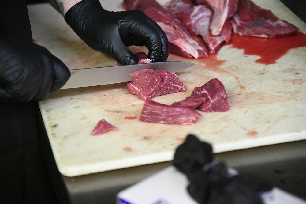 Kory Hill, line cook at Steinhaus Keller, cuts up a steak for goulash. - Photo by Tanner Newton of The Sentinel-Record