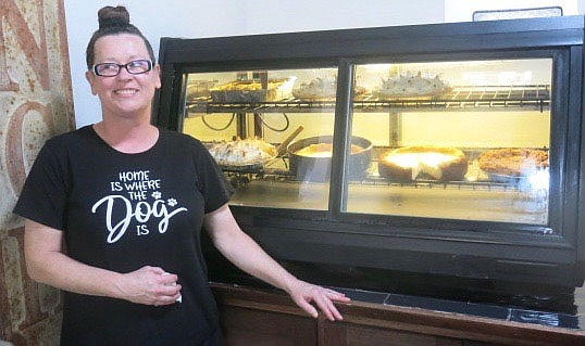 Westside Eagle Observer/SUSAN HOLLAND
Carol Thompson poses beside the pie case at 59 Diner to show off some of the tasty baked goods offered to diners at the cafe she and Mike Wilson opened near the end of July. On Thursday, Sept. 2, the selections included peach cobbler, cheesecake, coconut meringue, chocolate meringue, peanut butter and Dutch apple pies.