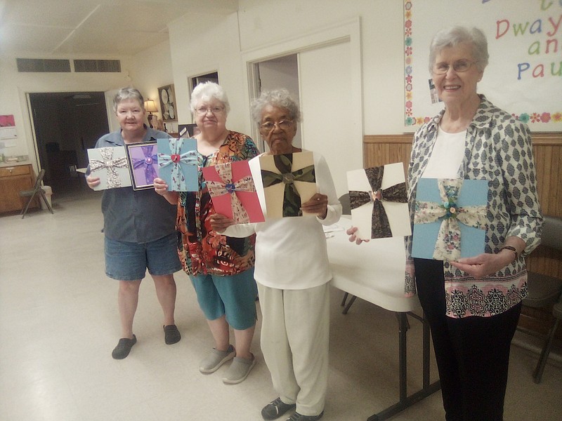 Grand Prairie Quilt Society members show off their fabric crosses they made at the demonstration. (Special to The Commercial)