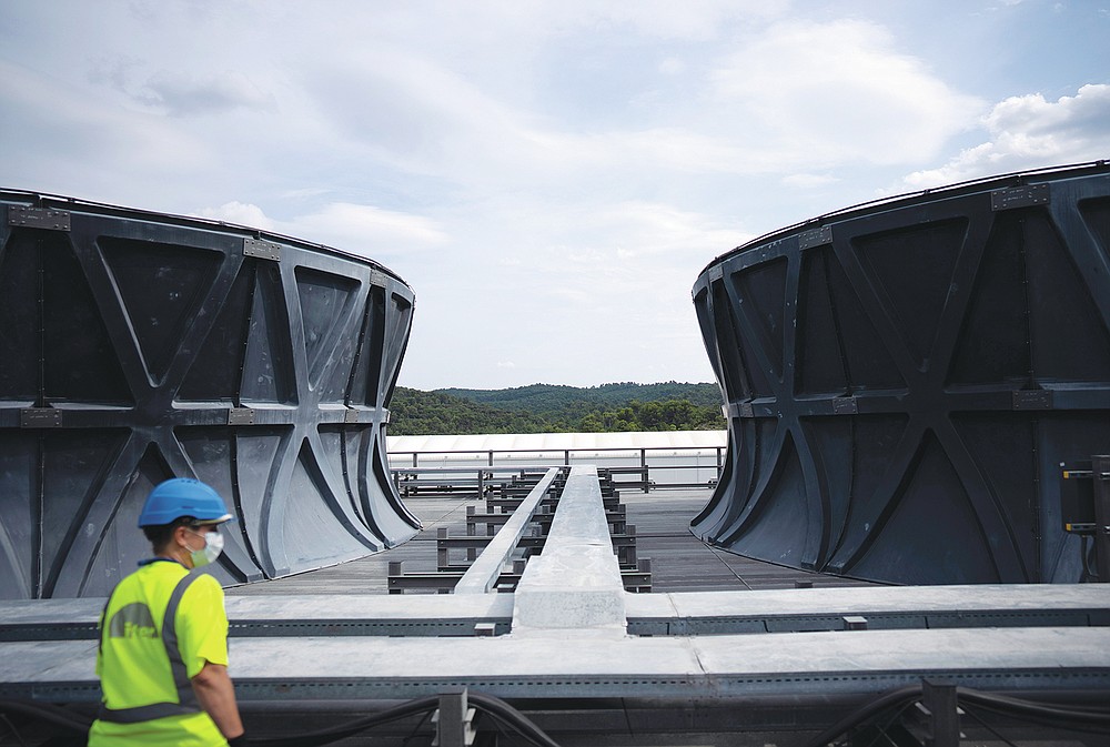 A worker surveys the cooling tower area of the ITER machine in Saint-Paul-Lez-Durance, France, Thursday, Sept. 9, 2021. Scientists at the International Thermonuclear Experimental Reactor in southern France took delivery of the first part of a massive magnet so strong its American manufacturer claims it can lift an aircraft carrier. (AP Photo/Daniel Cole)