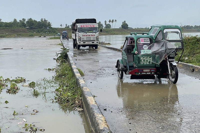 Motorists cross a bridge as the river starts to swell due to approaching typhoon Chanthu in Cauayan, Isabela province, northern Philippines, Friday Sept. 10, 2021. Typhoon Chanthu skirted past most of the Philippines on Friday but appeared to be gaining strength and heading directly for Taiwan this weekend, forecasters said. (AP Photo)