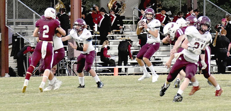 MARK HUMPHREY  ENTERPRISE-LEADER/Lincoln sophomore quarterback Drew Moore (No. 2) drops back in the pocket to pass as senior wide receiver Lincoln Morphis (No. 21) gets into his route. The Wolves dropped the nonconference football contest 48-0 on Friday.