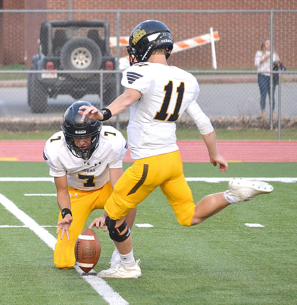 ANNETTE BEARD PEA RIDGE TIMES/Prairie Grove junior Payton Higgins (Tiger No. 11) kicks for the extra-point out of the hold of Camden Patterson (No. 7) after a Tiger touchdown Friday, Sept. 10, 2021.