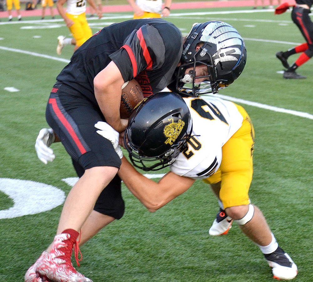 ANNETTE BEARD PEA RIDGE TIMES/Prairie Grove senior Colin Faulk (Tiger No. 20) tackles Blackhawk sophomore Bowen Phillips (No. 41) Friday, Sept. 10. Prairie Grove held the Blackhawks scoreless in the second and third quarters while posting a 41-28 nonconference football win.