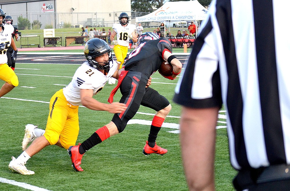 ANNETTE BEARD PEA RIDGE TIMES/Prairie Grove junior Rhett Marrell (Tigers No. 21) tries to tackle Blackhawk senior Trevor Blair (No. 8) on Friday, Sept. 10, 2021. The Tigers emerged victorious on the road by a 41-28 score.