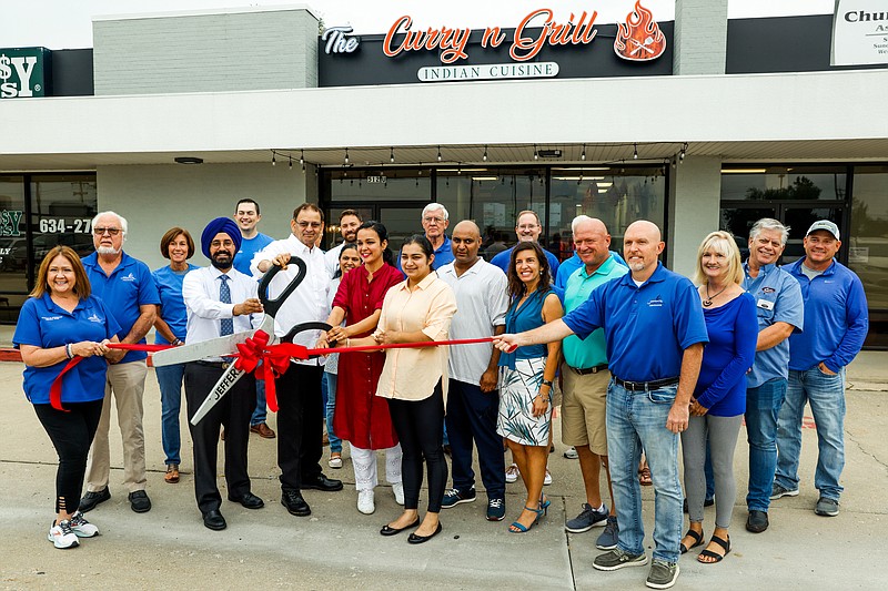 Ethan Weston/News Tribune - Members of the Jefferson City chamber of commerce and city officials gather around Manpreet Kaur, Sandeep Gill, Surjeet Toora, Harshdeep Bhasin and Gupreet Gill at the grand opening of Curry n' Grill.