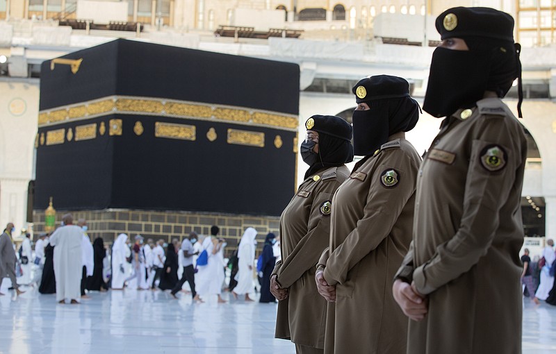 In this July 20 photo, Saudi police women, who were recently deployed to the service, from right to left, Samar, Alaa, and Bashair, stand alert in front of the Kaaba, the cubic building at the Grand Mosque, during the annual hajj pilgrimage in the Saudi Arabia's holy city of Mecca. The cloud of social restrictions that loomed over generations of Saudis is quickly dissipating and the country is undergoing visible change. Still, for countless numbers of people in the United States and beyond, Saudi Arabia will forever be associated with 9/11. - AP Photo/Amr Nabil