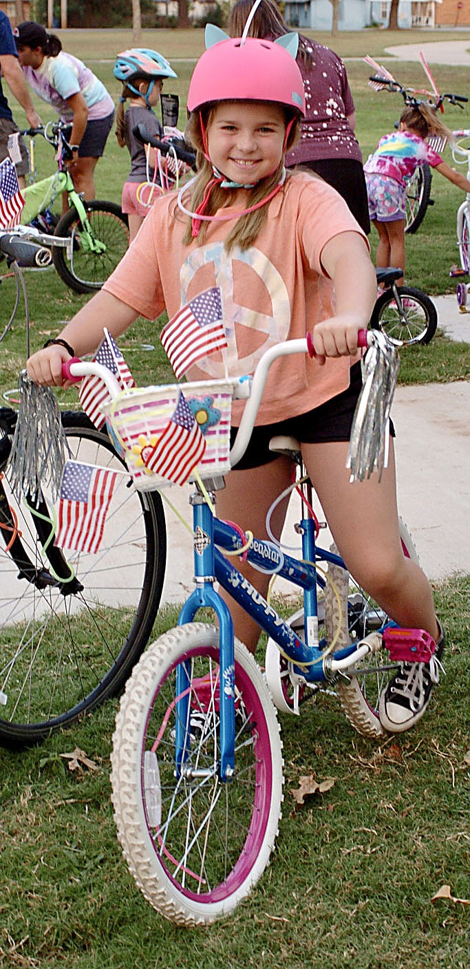 Westside Eagle Observer/RANDY MOLL
Grace Hughes, 8, shows off her decorated bicycle before the glow ride in Gentry on Saturday.