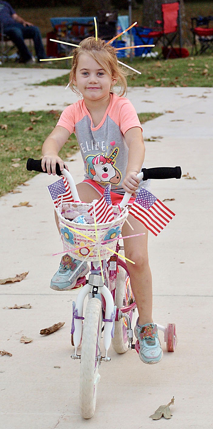 Westside Eagle Observer/RANDY MOLL
Harlee Gaines, 7, is decorated with glowsticks and American flags for the glow ride in Gentry on Saturday evening.
