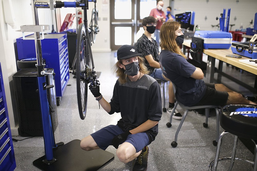 Cooper Heasley assembles a bike, Thursday, September 9, 2021 at the Northwest Arkansas Community College in Bentonville. The Northwest Arkansas Community College Workforce & Economic Development Division held an open house Aug. 20 for its new Bicycle Technician Lab. In April, the college was awarded a $1,246,864 grant from the Walton Family Charitable Support Foundation. Funding is being used for the phased roll-out of the college's new Bicycle Assembly and Repair Technician program. Check out nwaonline.com/210910Daily/ for today's photo gallery.
(NWA Democrat-Gazette/Charlie Kaijo)