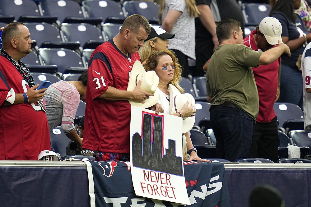 Houston Texans fans bow their heads during a 9/11 memorial video before an NFL football game against the Jacksonville Jaguars Sunday, Sept. 12, 2021, in Houston. (AP Photo/Sam Craft)