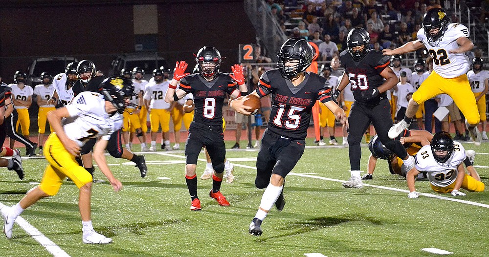 Sophomore quarterback Gavin Dixon, No. 15, evades Tiger defenders Friday, Sept. 10, 2021, as he makes a run.