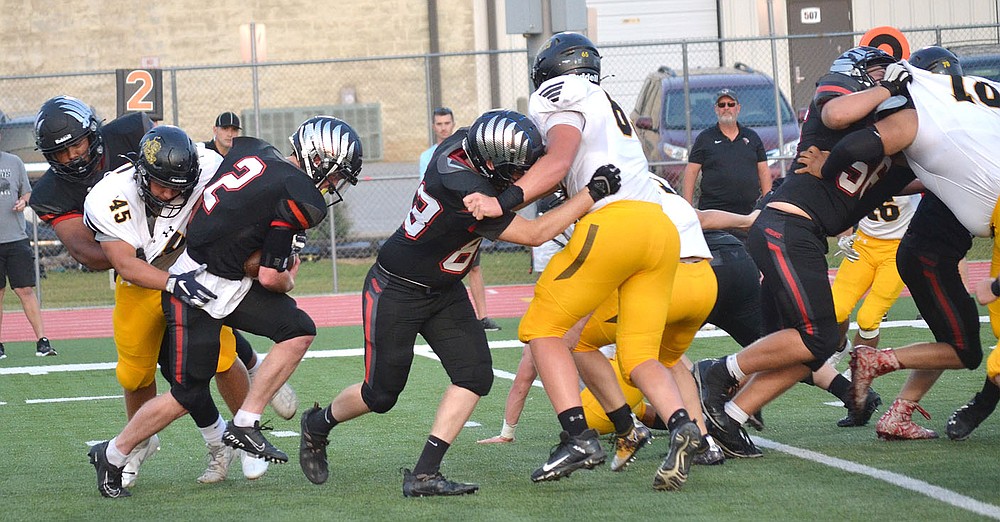 Senior Joe Adams, No. 2, tries to escape the grasp of a Tiger while being guarded by offensive linemen Friday, Sept. 10, 2021.