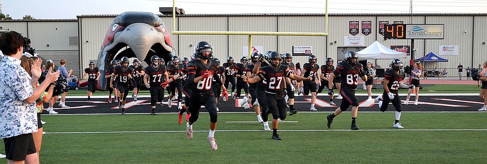 The Pea Ridge Blackhawk football team enters the stadium cheered by Blackhawk cheerleaders Friday, Sept. 10, 2021.