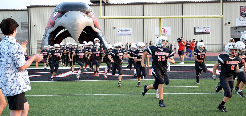 Pee Wee Blackhawks ran out of the Hawk head tunnel behind the varsity Blackhawks Friday, Sept. 10, 2021, before the game against Prairie Grove.